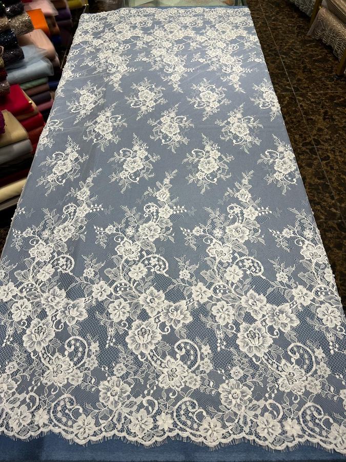 Pearl-beaded corded French lace displayed in showroom